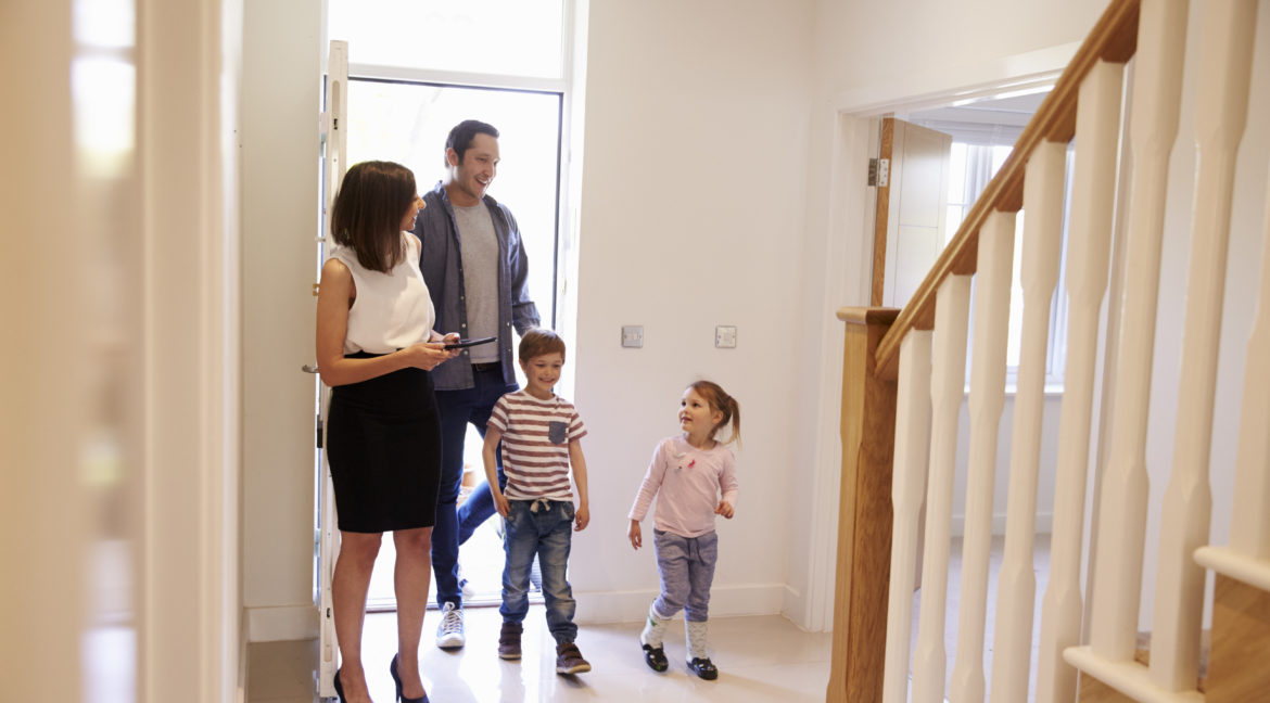 Realtor Showing Young Family Around Property Listing